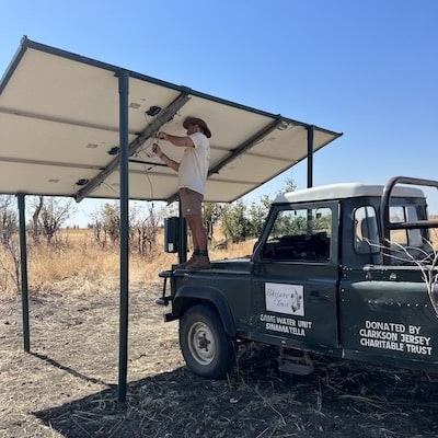 Volunteer fixing solar panels in Zimbabwe